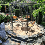 Pavillon Milano pulverbeschichtet anthrazit mit Messingkugel in einem Garten