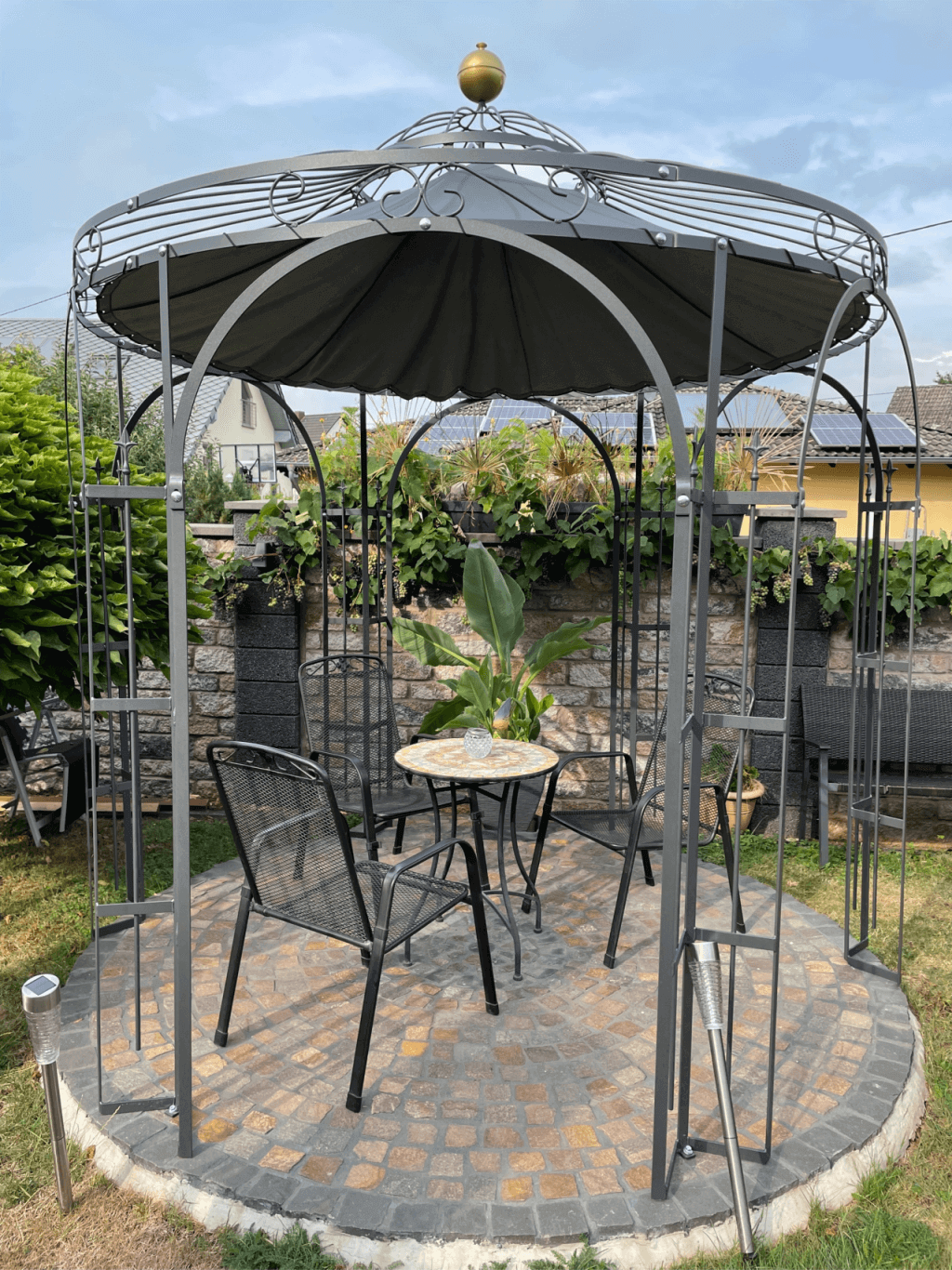 Pavillon Milano pulverbeschichtet anthrazit mit Messingkugel und Sonnensegel in Anthrazit in einem Garten