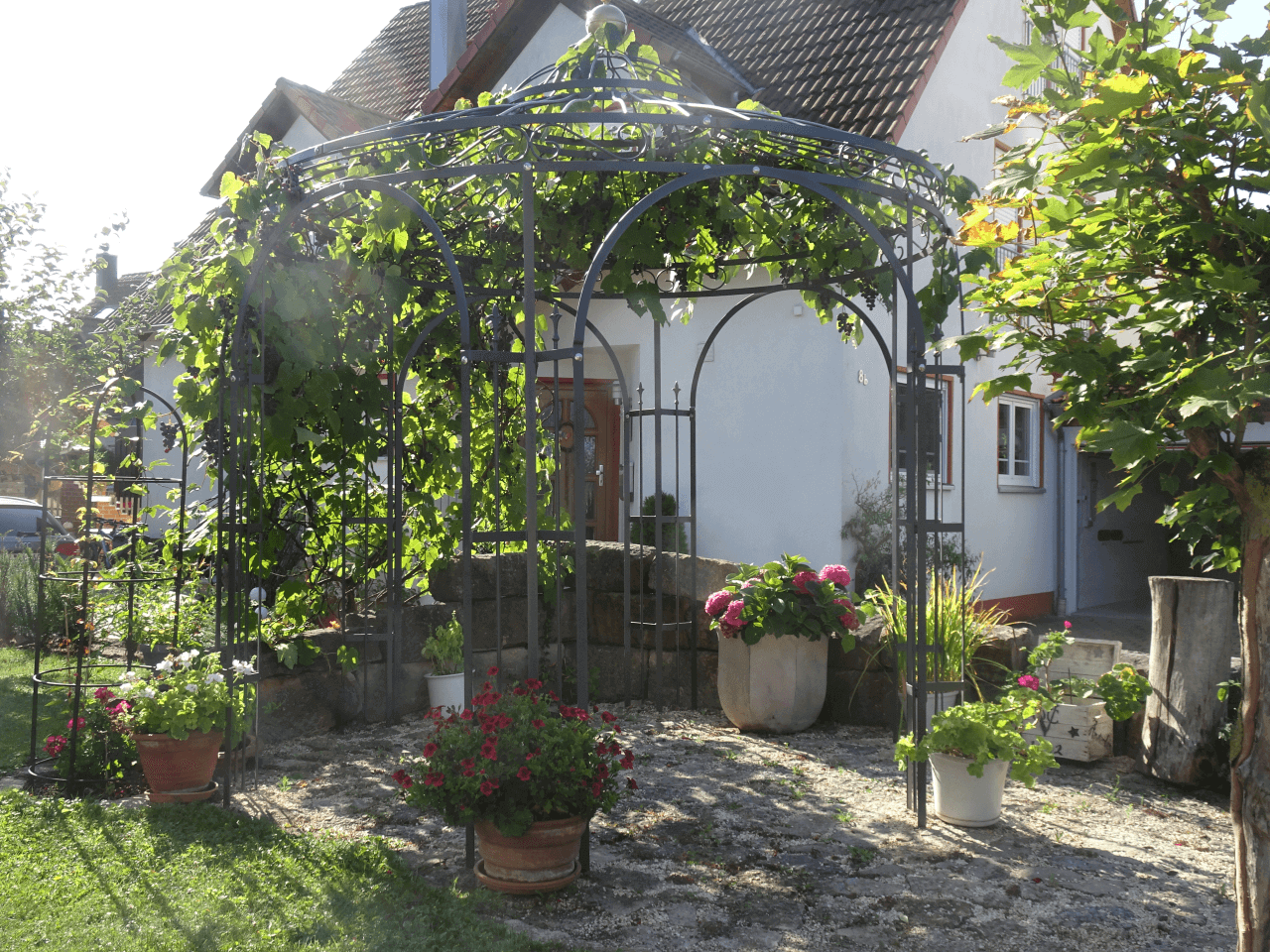 Weinpavillon Milano mit Messingkugel in einem Garten