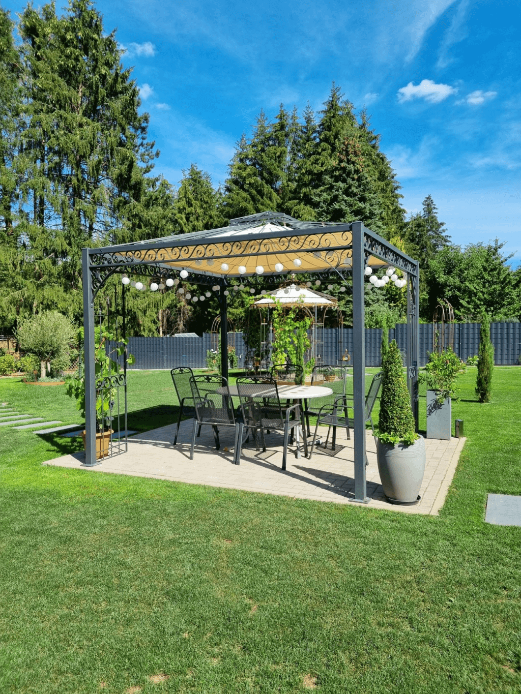 Pavillon Genua pulverbeschichtet anthrazit mit Sonnensegel in Ecru in einem Garten