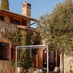 Pergola Ischia in feuerverzinkter Ausführung an einer terrasse angelehnt mit Sitzgelegenheiten und Sonnensegel