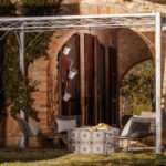 Pergola Ischia in feuerverzinkter Ausführung an einer terrasse angelehnt mit Sitzgelegenheiten und Sonnensegel