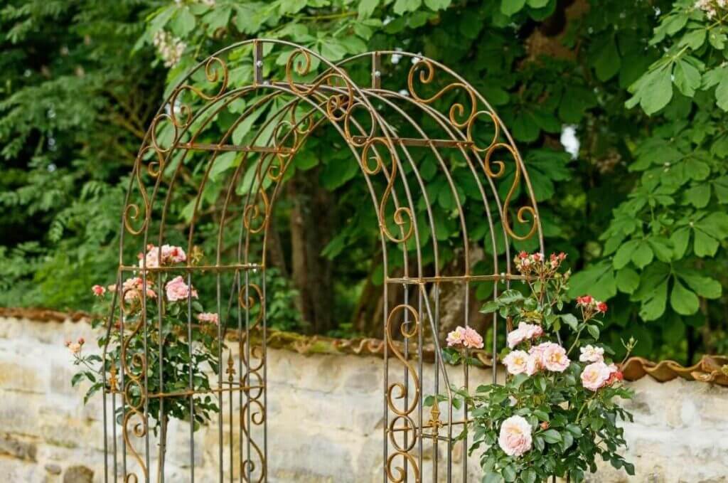 Berankter Rosenbogen als Eingang zum Bauerngarten