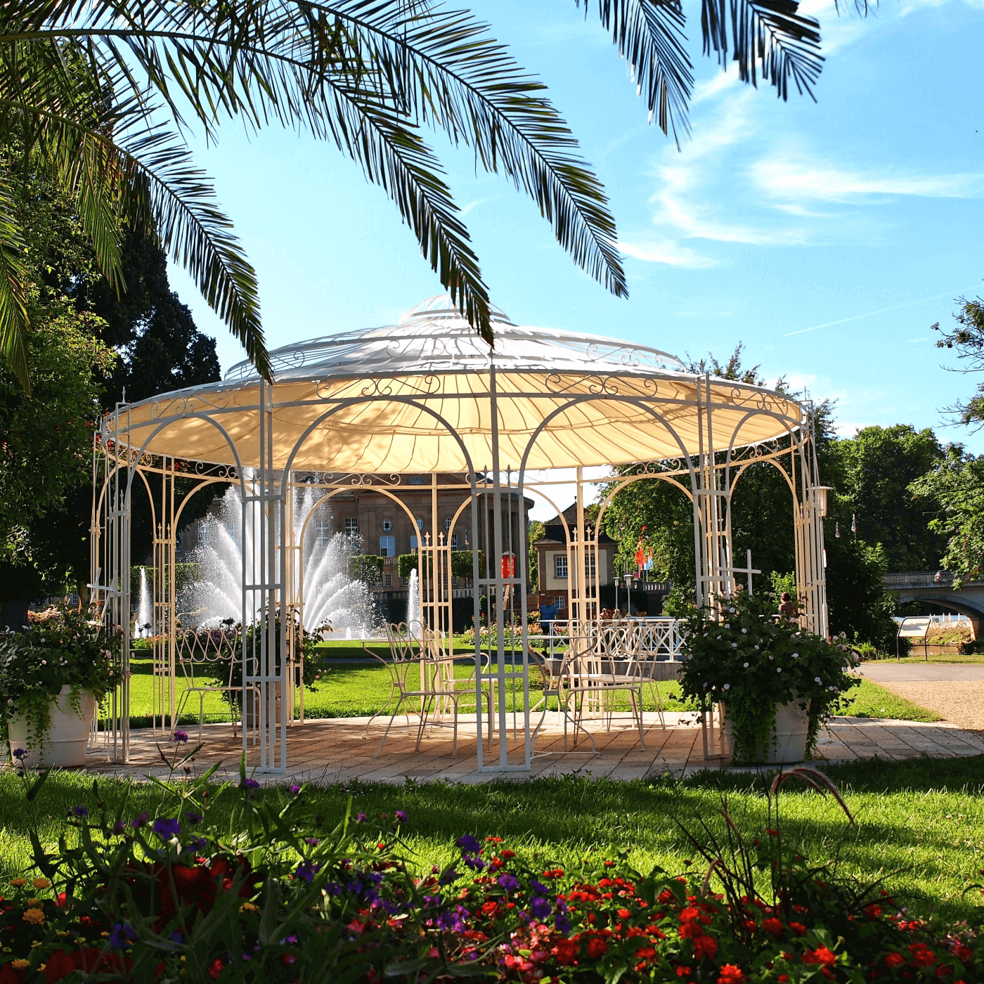 Luxuspavillon Toskana in Weiss mit Sonnensegel und Sitzgruppen vor einem Springbrunnen