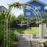 Rosenbogen Cremona  pulverbeschichtet cremeweiss in einem Garten